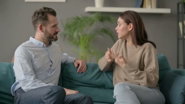 Σοβαρή γυναίκα μιλάει με τον άνθρωπο, ενώ κάθεται στον καναπέ  - Πλάνα, βίντεο