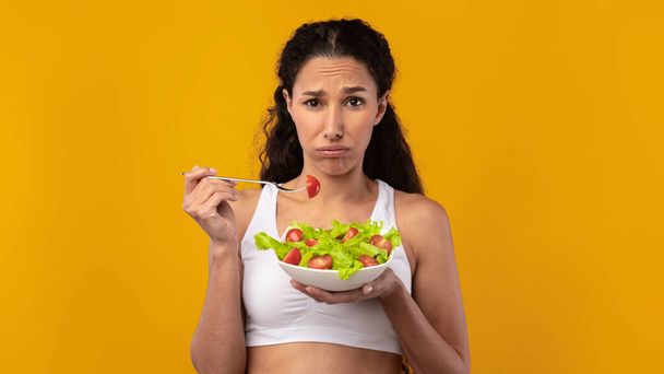 Portrét smutné dámy držící talíř se zeleninovým salátem - Fotografie, Obrázek