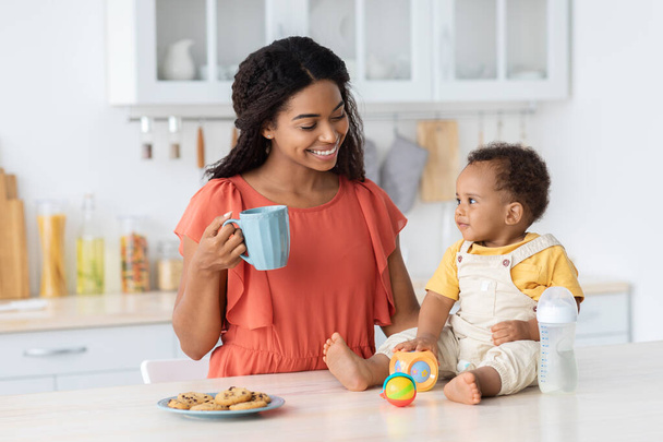Boldog fekete család anya és csecsemő fia töltenek időt a konyhában - Fotó, kép