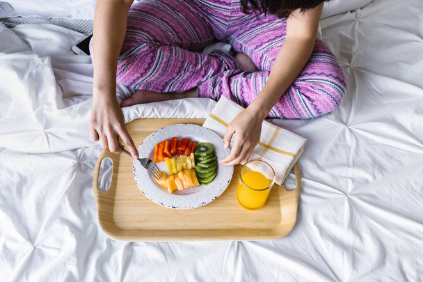 Jonge latijnse vrouw geniet van ontbijt in bed thuis in Mexico Latijns-Amerika - Foto, afbeelding
