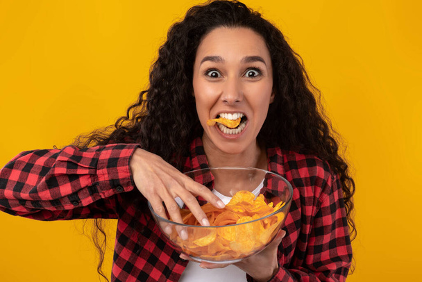 おいしいジャガイモのクリスピーを食べる興奮ラテン語の女性 - 写真・画像
