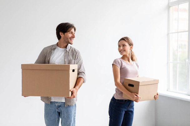 satisfeitas millennial caucasiano masculino e feminino carregando caixas de papelão com pertences, realocação - Foto, Imagem