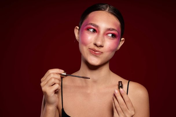 módní žena make-up štětec čistá kůže jasný make-up pózovat růžové pozadí beze změny - Fotografie, Obrázek