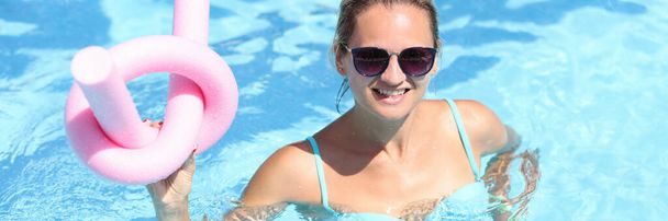 Portré fiatal nő napszemüvegben medencében rugalmas bottal - Fotó, kép