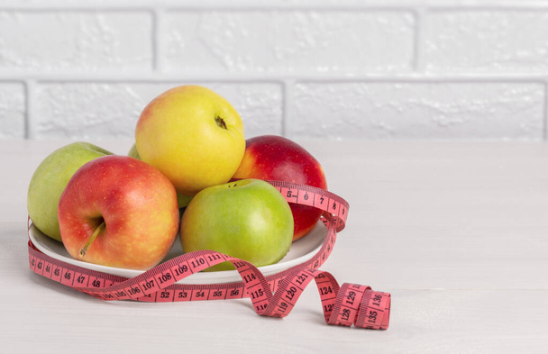 Φρέσκα μήλα και μεζούρα. Η έννοια της σωστής διατροφής και ενός υγιεινού τρόπου ζωής. - Φωτογραφία, εικόνα