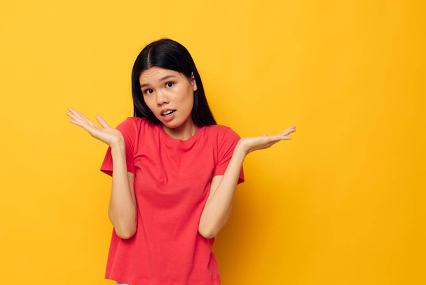 woman with Asian appearance gestures with her hands in casual clothes copy-space isolated background unaltered - Foto, afbeelding