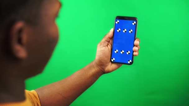 Αφρο-Αμερικανός άνθρωπος κρατά smartphone με δείκτη εντοπισμού σε αυτό και το σκούπισμα αριστερά στο κλειδί chroma - Πλάνα, βίντεο