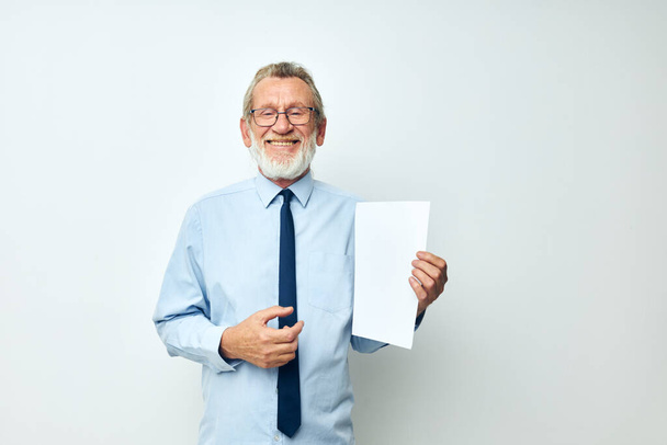 Portrait of happy senior man in a shirt with a tie copy-space sheet of paper cropped view - Foto, afbeelding