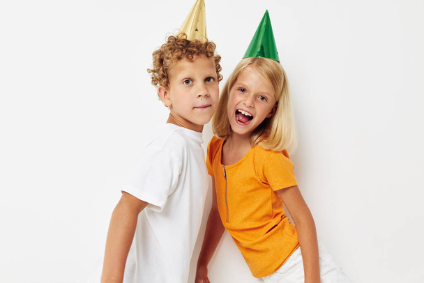 vrolijk kinderen poseren emoties vakantie kleurrijke caps geïsoleerde achtergrond ongewijzigd - Foto, afbeelding
