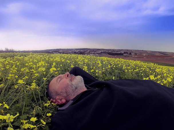 Homme adulte dans un champ fleuri fin janvier - Photo, image