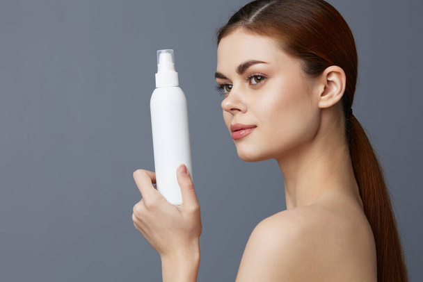young woman body lotion rejuvenation cosmetics Gray background - Fotó, kép