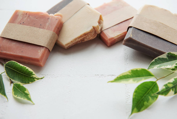 Assorted handmade soap bars and green leaves - Photo, Image