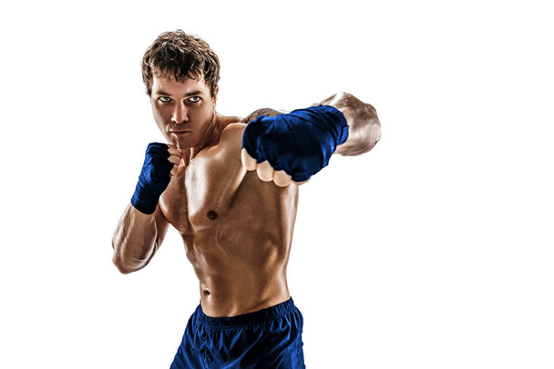 Studio shot of aggressive boxer who training, practicing swing on white background. Blue sportswear - Foto, Imagen