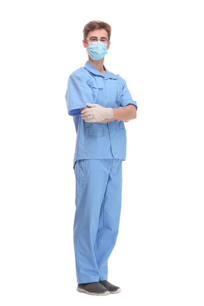 Doctor wearing a surgical mask against infections standing with crossed arms in a lab coat isolated on white - Valokuva, kuva