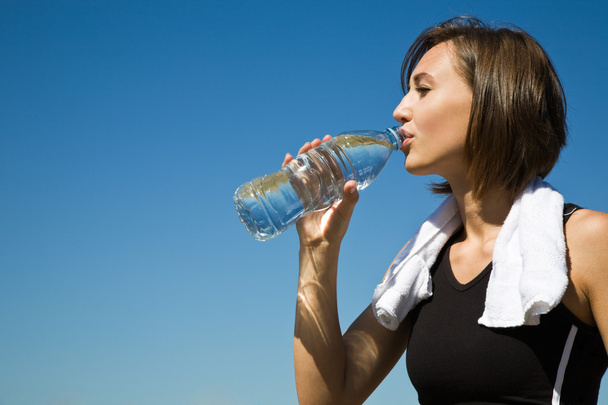 Valkoihoinen tyttö juomavesi liikunnan jälkeen
 - Valokuva, kuva