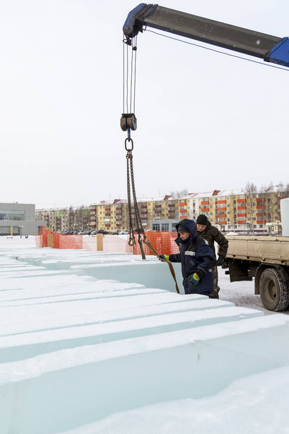 Dos trabajadores de ensamblaje descargan placas de hielo del cuerpo de un automóvil - Foto, Imagen