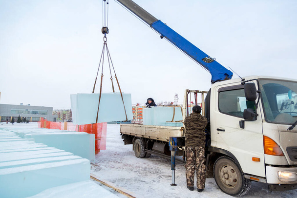 Due operai di montaggio scaricano lastre di ghiaccio dalla carrozzeria di un'auto - Foto, immagini
