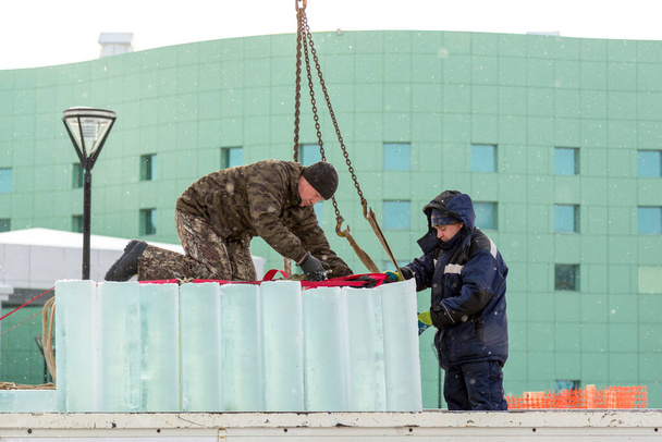 Робітники взимку костюмують вітрові кільця під крижаним блоком на будівельному майданчику
 - Фото, зображення