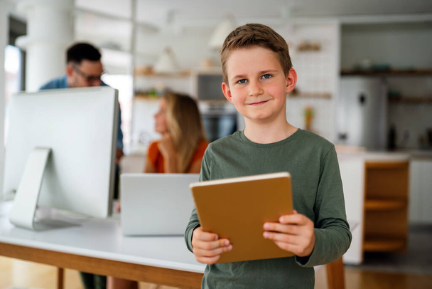 Home schooling social distance e-learning online education concept. Happy school boy using tablet at home. - Fotografie, Obrázek