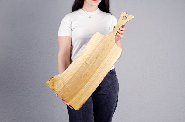 Beautiful girl. Cutting board. Young woman hold a large kitchen board in her hands. - Fotografie, Obrázek