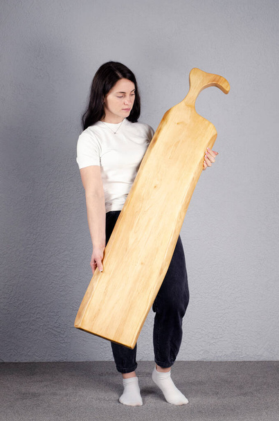 Beautiful girl. Cutting board. Young woman hold a large kitchen board in her hands. - Photo, Image