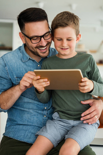 Portrait of father and child using digital tablet for e-learning. Education home school digital device kid concept. - Foto, Imagem
