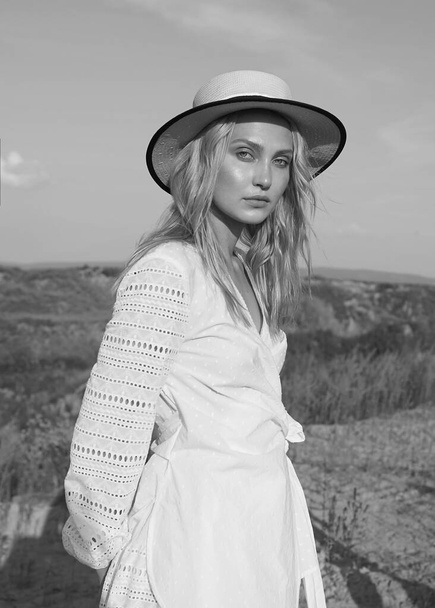 Gorgeous young woman in white romantic clothes on the summer field. Sunny day. Blonde model with big beautiful eyes and nice lips. Calm and balance. Fashionable. Black and white. Emotional portrait. - Foto, Bild