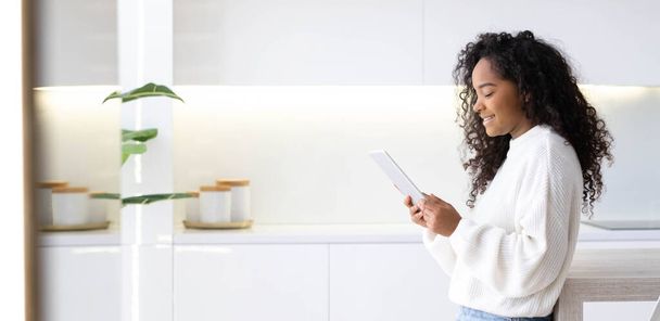 Banner African American Girl using iPad tablet at home pressing finger, reading social media internet, typing text or shopping online. Freelancer Remotely working online at home. - Valokuva, kuva