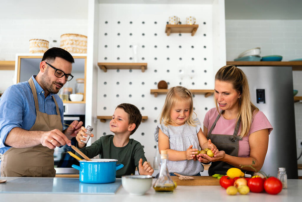 Happy young family preparing healthy food together in kitchen. People happiness cooking concept - Φωτογραφία, εικόνα