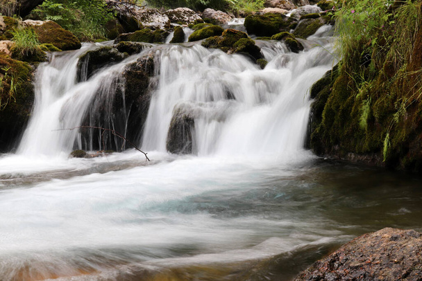 cascada que fluye a través de rocas musgosas - Foto, Imagen