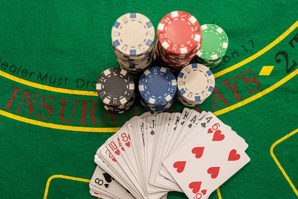 balíček karet rozložený vějířem s barevnými žetony na zeleném pokerovém stole. Poker koncept. Herní koncept - Fotografie, Obrázek
