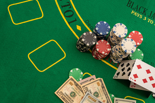 cartas hechas de casas al lado de los dólares y fichas se encuentran en una mesa de póquer verde. Concepto Poker - Foto, Imagen