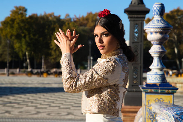 Tancerka flamenco, kobieta, brunetka i piękna, typowa hiszpańska tancerka tańczy i klaska dłońmi na placu w Sewilli. Koncepcja Flamenco dziedzictwa kulturowego ludzkości. - Zdjęcie, obraz