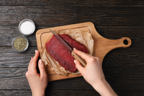 Concept of cooking with raw beef steak on wooden background - 写真・画像