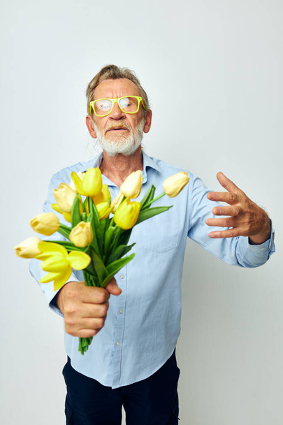 Retrato de feliz hombre mayor ramo amarillo de flores posando fondo aislado - Foto, imagen