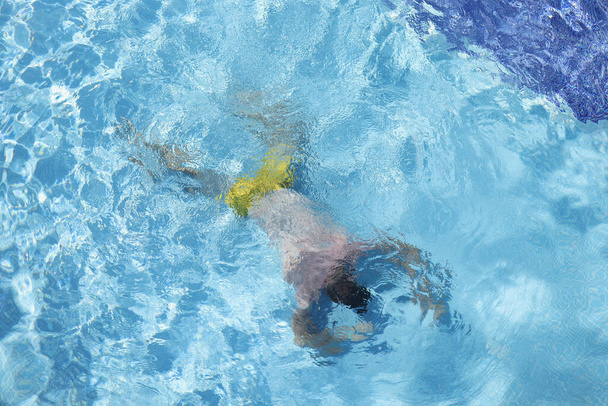 Мужчина лежит на дне бассейна вид сверху - Фото, изображение