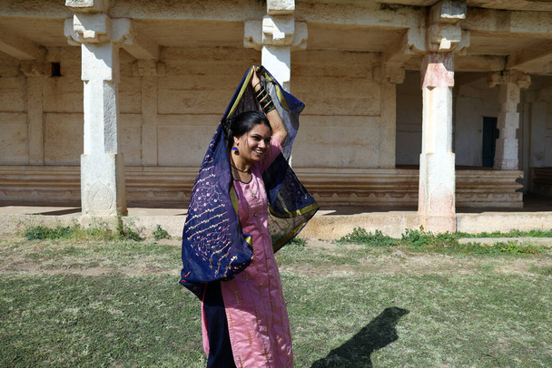 Una joven india tradicional bailando frente a un templo en el Fuerte Chitradurga, Karnataka, India. - Foto, Imagen