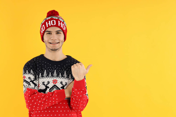 Ελκυστικός τύπος σε χριστουγεννιάτικο πουλόβερ σε κίτρινο φόντο - Φωτογραφία, εικόνα