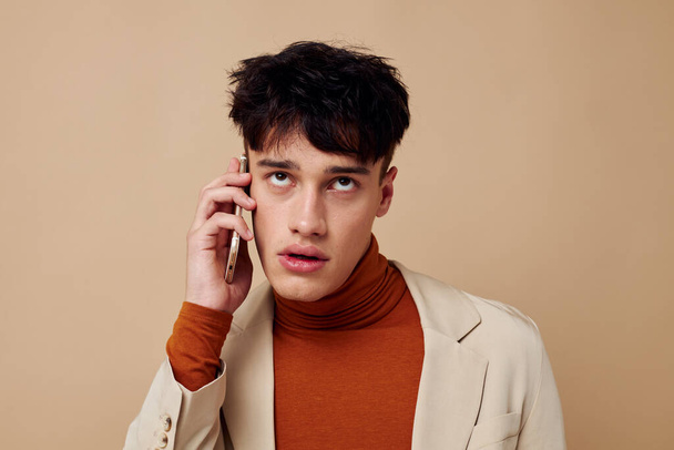 handsome guy posing with a phone in his hands in a jacket elegant style Lifestyle unaltered - Zdjęcie, obraz