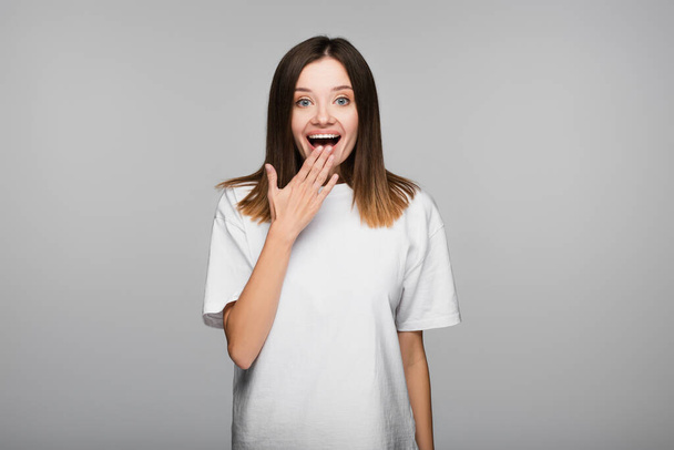 overjoyed woman with open mouth looking at camera isolated on grey - Foto, afbeelding