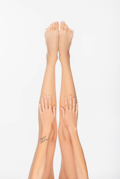 partial view of young woman with tattooed arm and slender legs isolated on white - Φωτογραφία, εικόνα