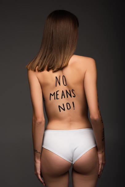 young woman in panties, with no means no inscription on back isolated on dark grey - Photo, Image
