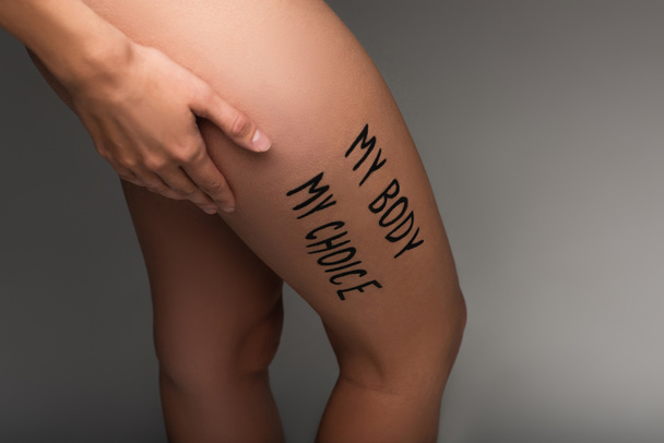 cropped view of nude woman with my body my choice lettering on hip isolated on dark grey - Foto, Imagen
