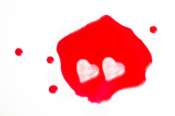 Cubos de hielo en forma de corazón en jugo rojo
 - Foto, Imagen