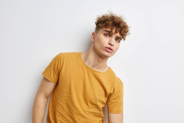 handsome young man in yellow t-shirts gesture hands emotions Lifestyle unaltered - Foto, Bild