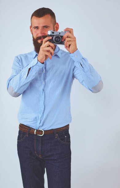 Young beard man focusing at you with his camera while standing - Fotoğraf, Görsel