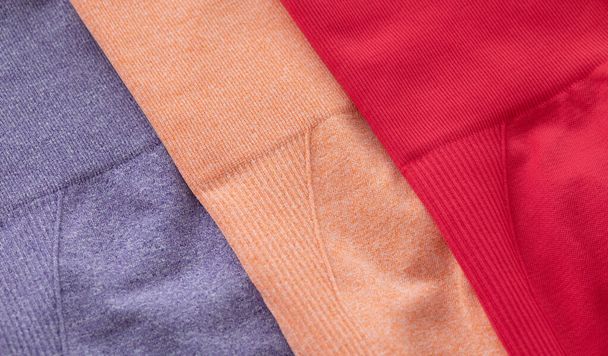 close-up view of bright colourful sports leggings on grey background. set of clothes for fitness - Φωτογραφία, εικόνα