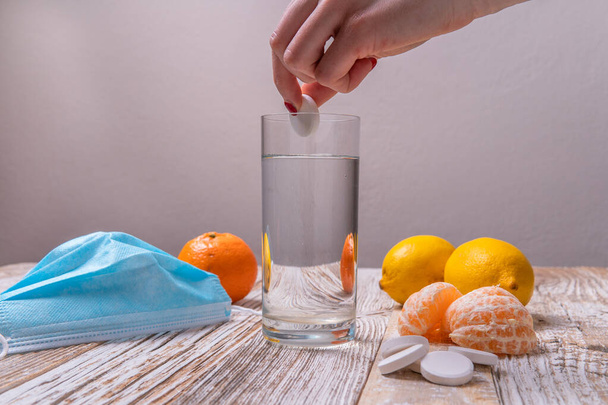 bebida com vitamina C. comprimido efervescente em um copo claro de água em uma mesa de madeira vista lateral. - Foto, Imagem