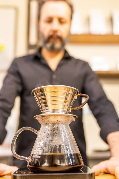 barista κάνει αμερικανικό καφέ σε ένα φίλτρο. - Φωτογραφία, εικόνα