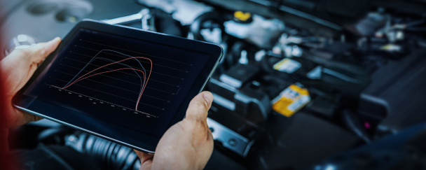 car engine ecu remapping and diagnostics. mechanic using digital tablet to check vehicle performance after chiptuning - Photo, Image